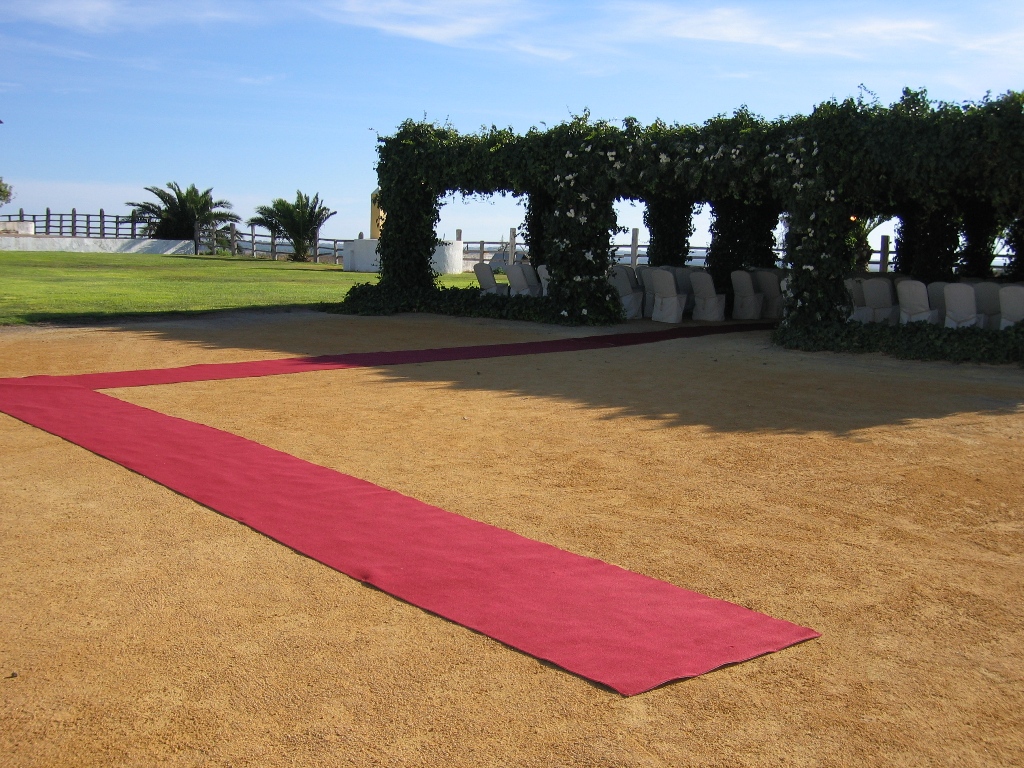 Ceremonia civil en la pérgola con alfombra roja en Dehesa Bolaños