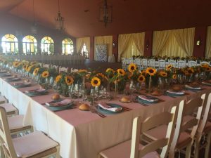 Salones con mesas imperiales y centros de girasoles para evento en Dehesa Bolaños