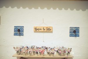 Seating plan en mesa antigua con macetas y fotos de invitados - Boda Carmen & Alexis en Dehesa Bolaños