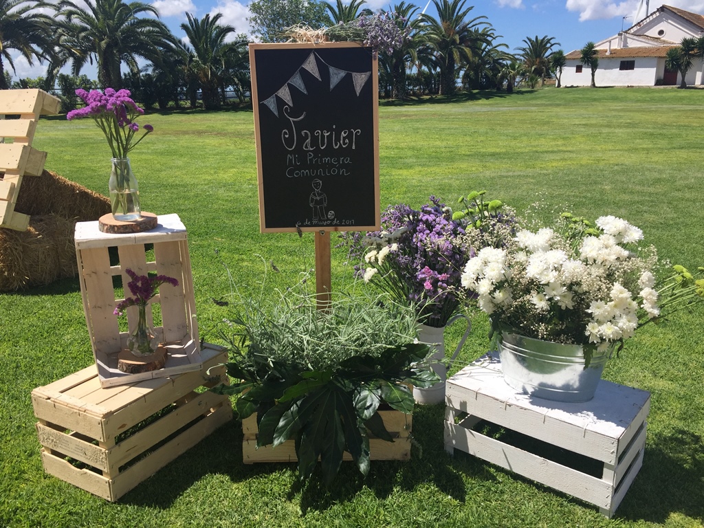 Cartel de bienvenida decorado con cajas y centros de flores - Comunión Javier en Dehesa Bolaños